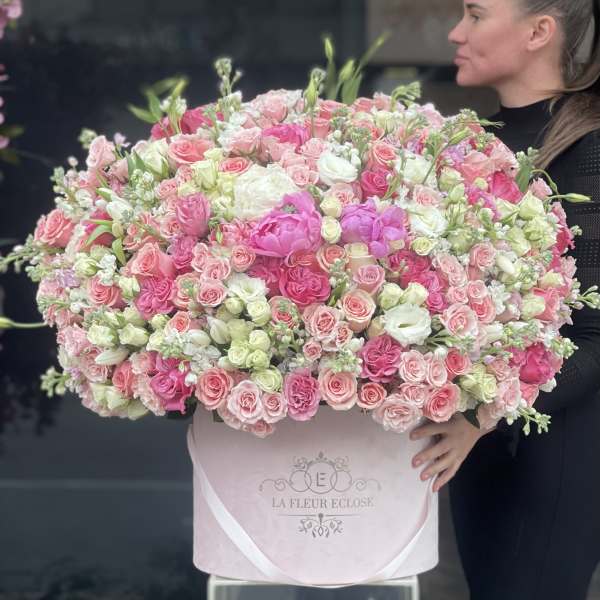 Large pink and white rose arrangement in a pink hat box