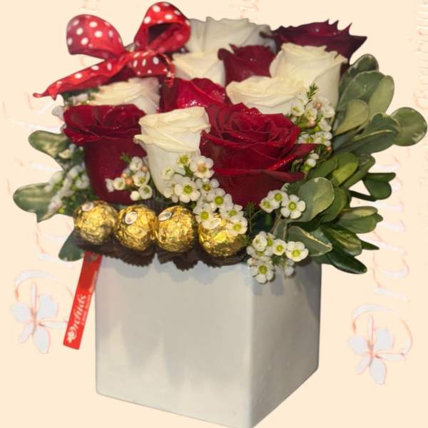 Red and white roses in a gray box with a polka-dot bow and chocolates
