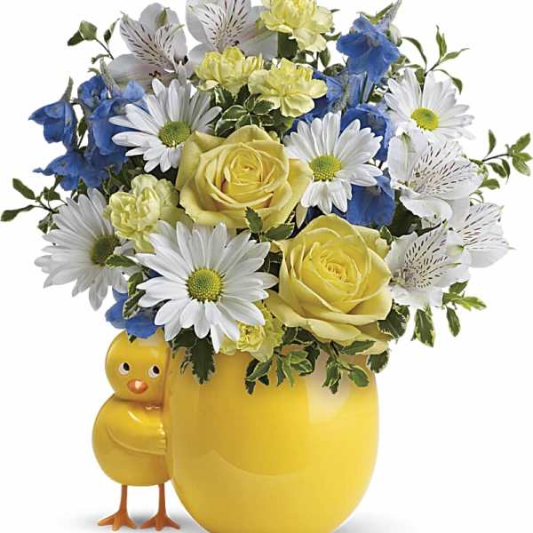 Yellow mug vase with daisies, roses, and blue flowers