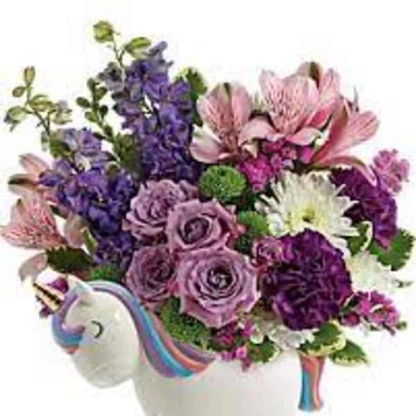 Bouquet of purple, pink, and white flowers in a unicorn-shaped vase
