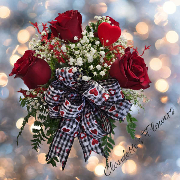 Bouquet of red roses with baby's breath and a heart-patterned ribbon