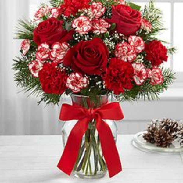 Red roses and carnations in a glass vase with a red ribbon