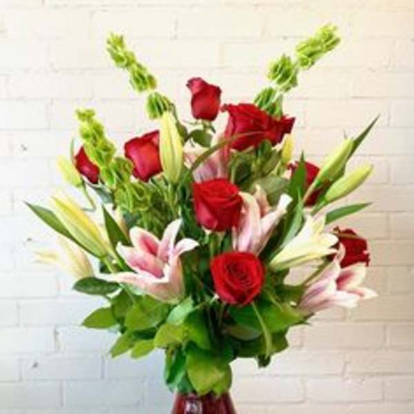 Red roses and pink lilies in a red glass vase