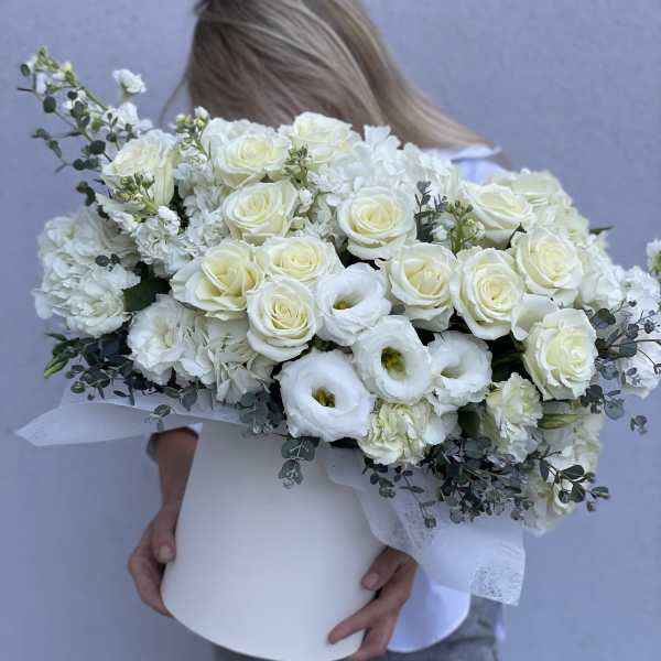 Large white bouquet of roses and lisianthus in a white hat box