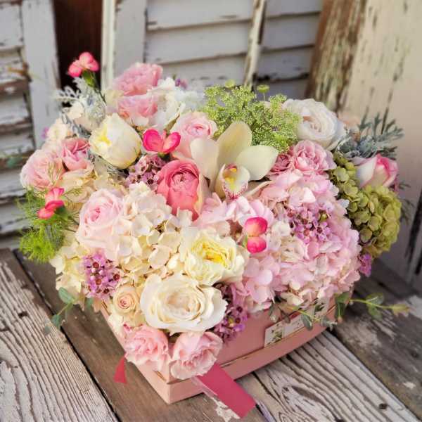 Pink and white mixed flower arrangement in a pink box