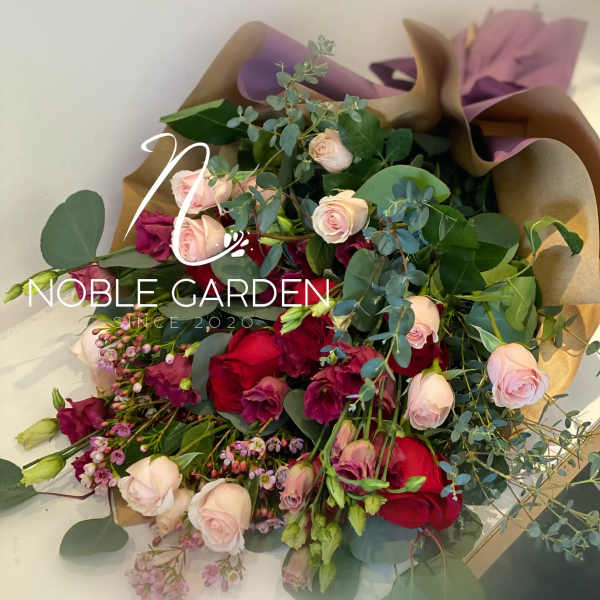 Bouquet of pink and red roses with eucalyptus in brown and purple wrap
