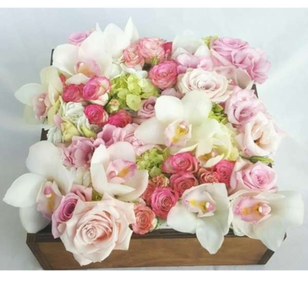 Pink and white floral arrangement in a wooden box
