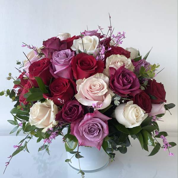 Bouquet of roses in pink, red, and white in a white vase