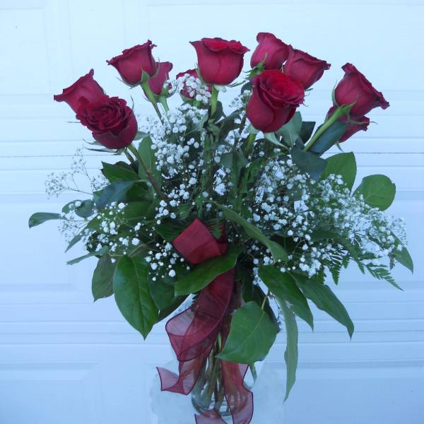 Bouquet of red roses with white baby's breath in a glass vase