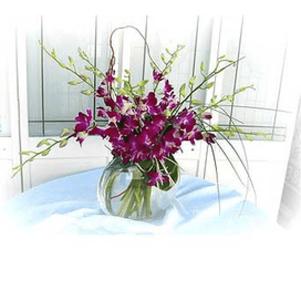 Purple orchid arrangement in a clear glass vase