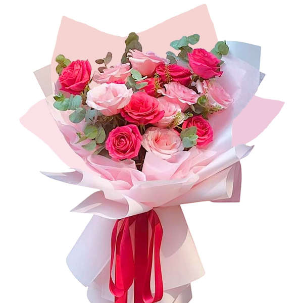 Bouquet of pink and blush roses wrapped in pale paper with a red ribbon