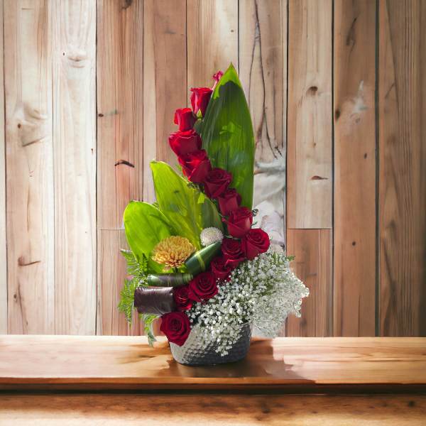 Tall arrangement of red roses with white baby's breath in a vase