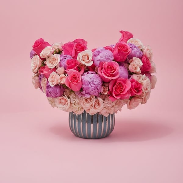 Pink and lavender rose bouquet in a striped vase
