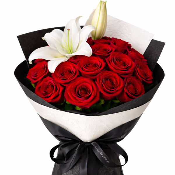 Bouquet of red roses with white lilies wrapped in black paper