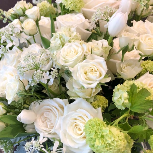 White roses and pale green hydrangeas in a dense bouquet