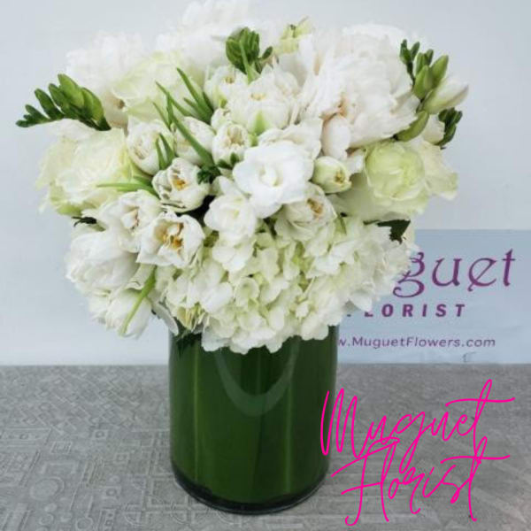 White floral arrangement in a green glass vase