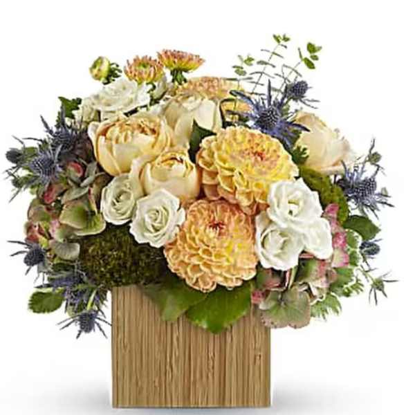 Mixed bouquet of cream, yellow, and white flowers in a wooden box