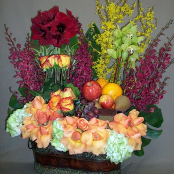 Colorful floral arrangement in a basket with fruit accents