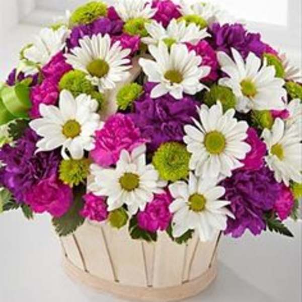 Bouquet of white daisies and purple-pink flowers in a round basket
