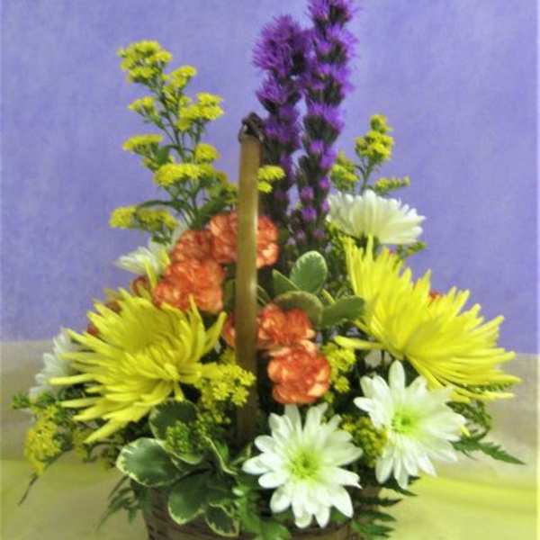 Basket arrangement with yellow, white, orange, and purple flowers