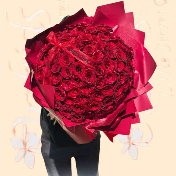 Large bouquet of red roses wrapped in red paper