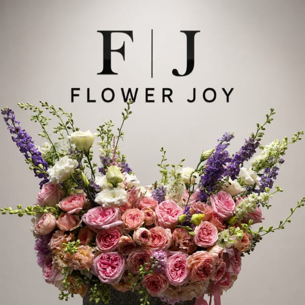 Large pink and purple floral arrangement in a dark container