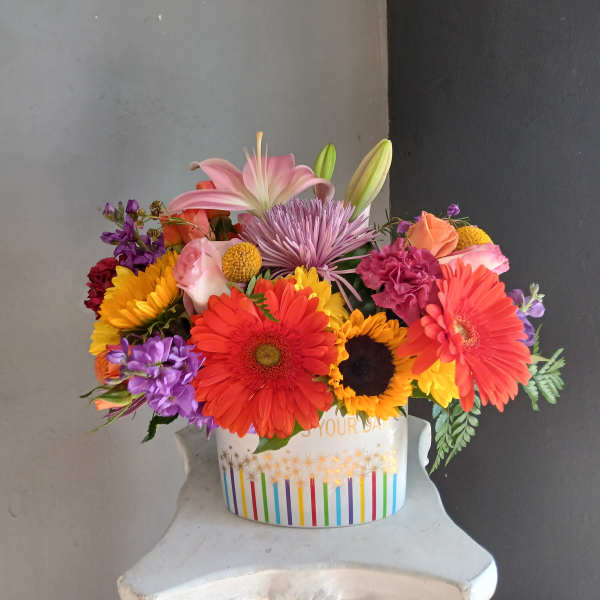 Colorful mixed bouquet in a decorated white container