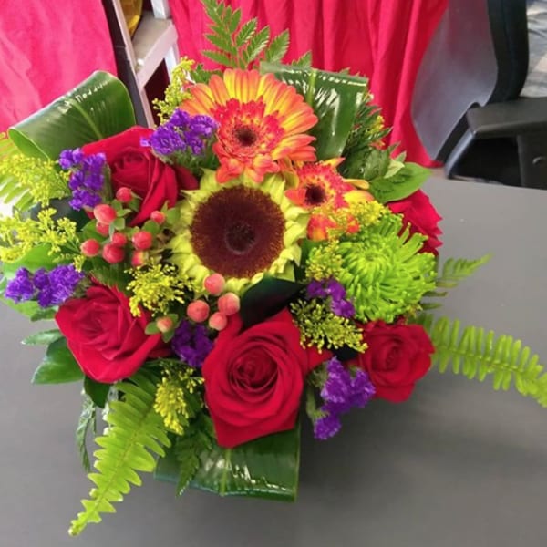 Bouquet of red roses and bright gerbera daisies with mixed filler flowers