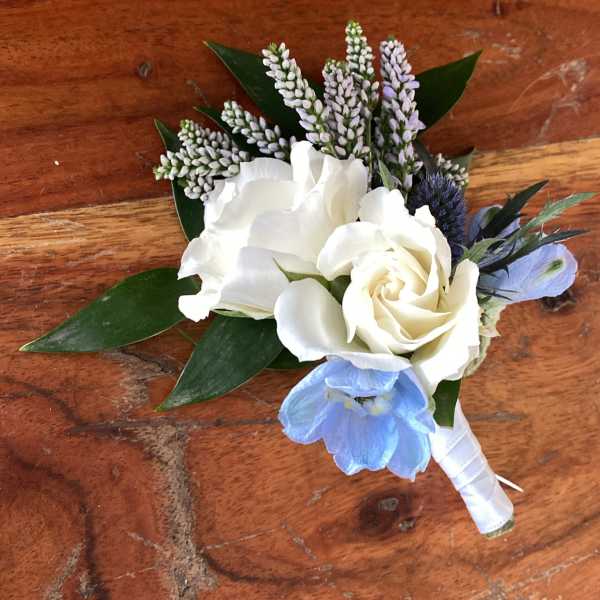 Small white and blue floral boutonniere with ribbon wrap
