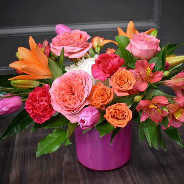 Pink and orange mixed bouquet in a magenta vase