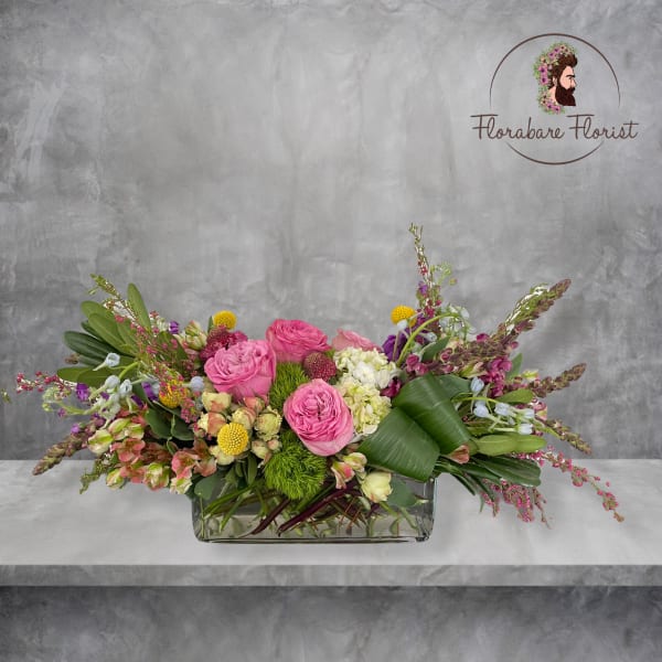 Mixed pink and white floral arrangement in a rectangular glass vase
