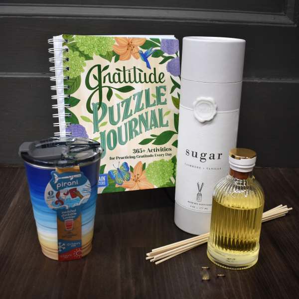 Gift set with a gratitude journal, tumbler, reed diffuser, and small bottle