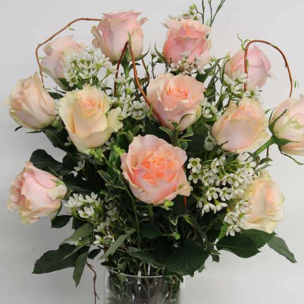 Pink and cream roses arranged in a clear glass vase