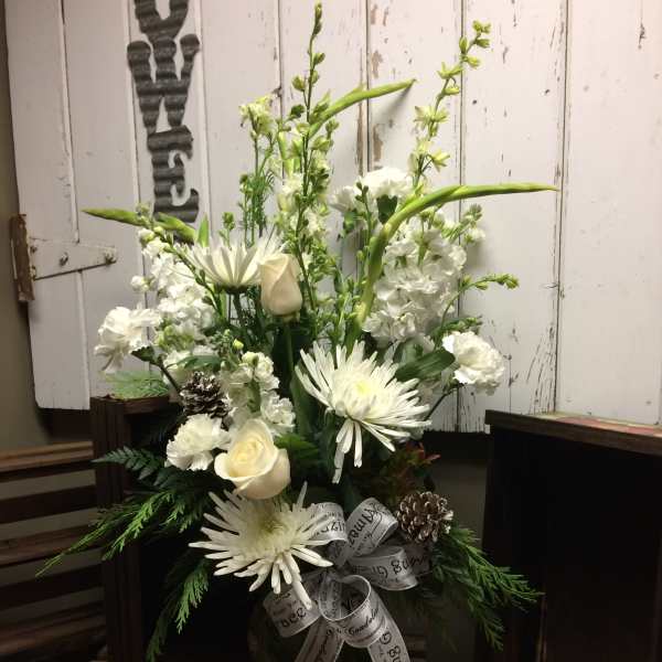 White floral arrangement with roses and daisies in a glass vase