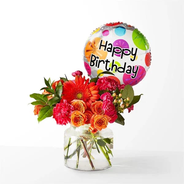 Birthday bouquet with orange and pink flowers in a glass vase and balloon