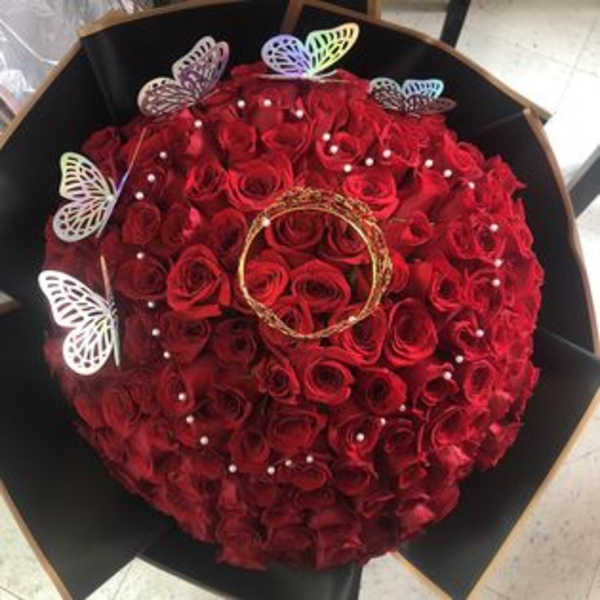 Round bouquet of red roses with butterfly picks and pearl accents