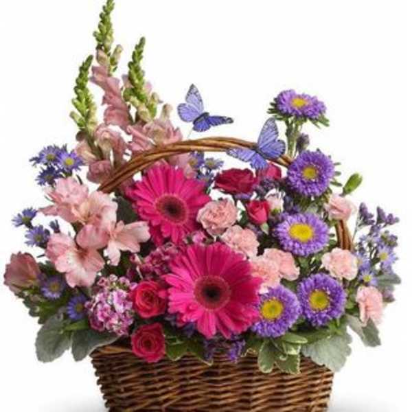 Basket arrangement with pink and purple flowers and butterfly accents