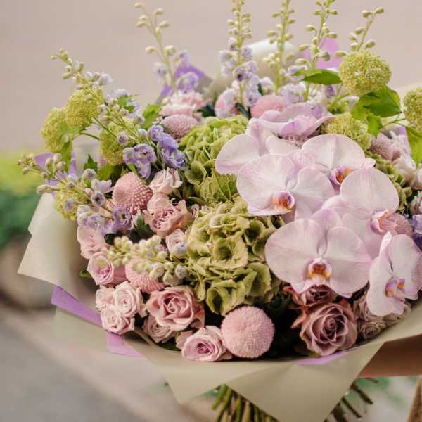 Bouquet of pale pink orchids, roses, and green hydrangeas