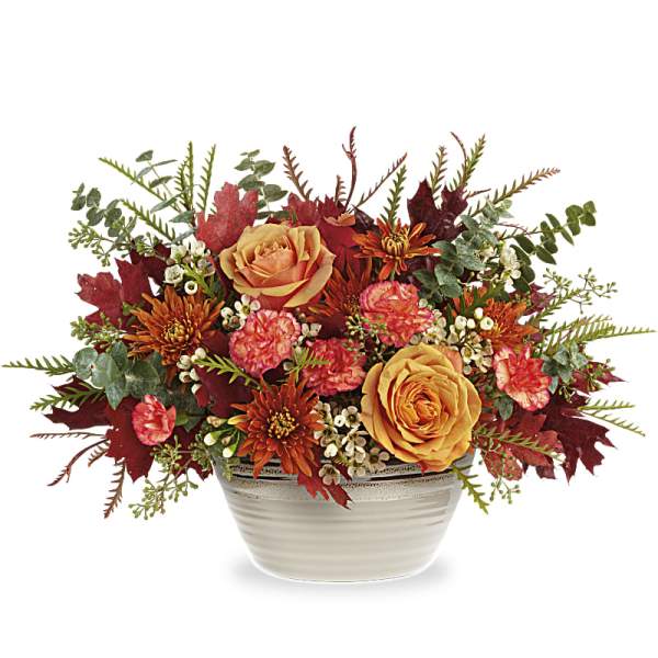 Autumn floral arrangement with orange roses in a white bowl vase
