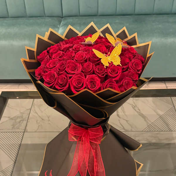 Bouquet of red roses wrapped in black paper with a red ribbon