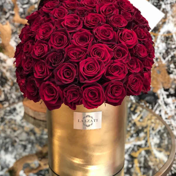 Bouquet of deep red roses in a gold cylindrical box