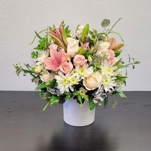 Pink and white mixed flower arrangement in a white vase