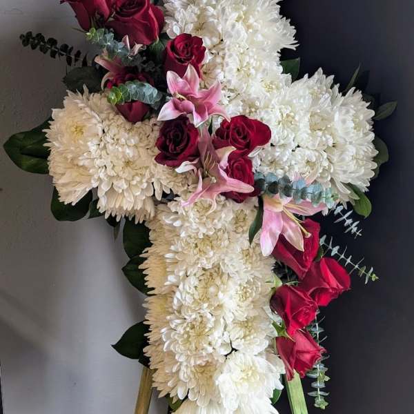 Cross-shaped floral spray with white chrysanthemums, red roses, and pink lilies