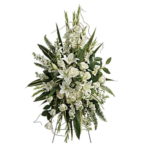 White floral standing spray on an easel with lilies and roses