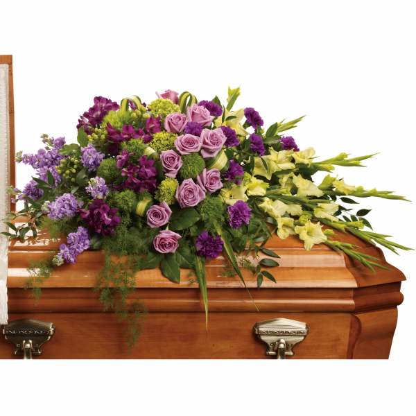 Casket spray with purple, pink, and yellow flowers
