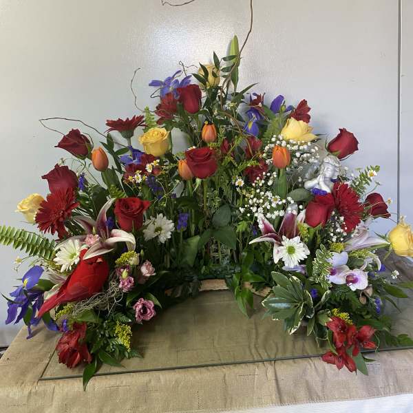 Large mixed floral arrangement with red and yellow roses and lilies