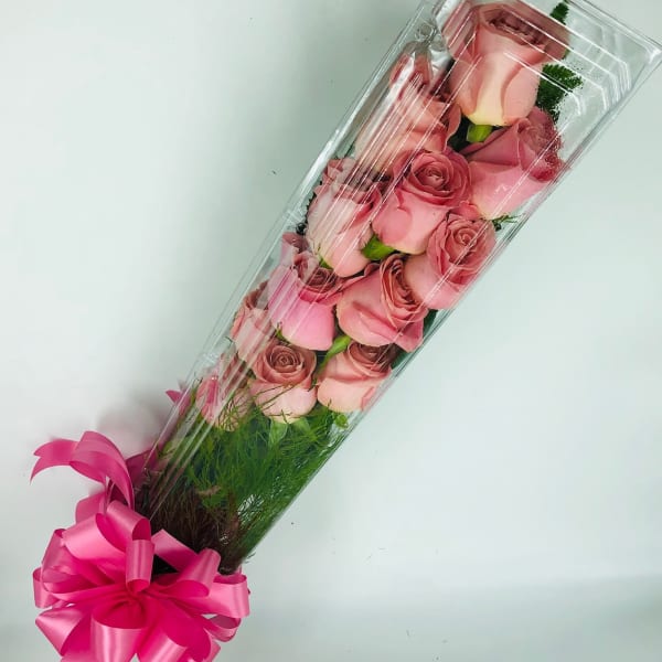 Long box of pink roses with a bright pink ribbon bow