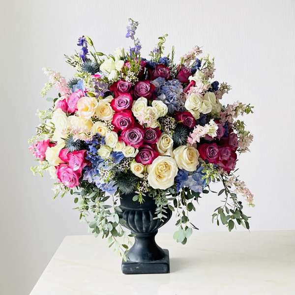Large mixed bouquet of roses and hydrangeas in a black urn vase