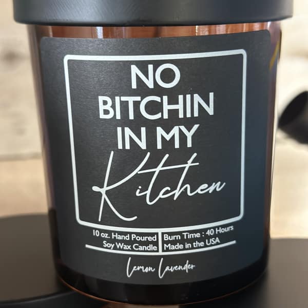 Black soy candle jar with a bold profanity label
