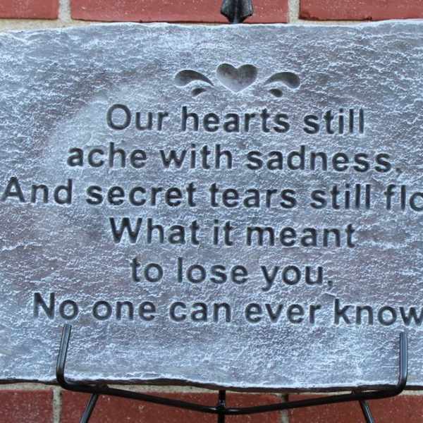 Stone memorial plaque with a sympathy poem on a stand